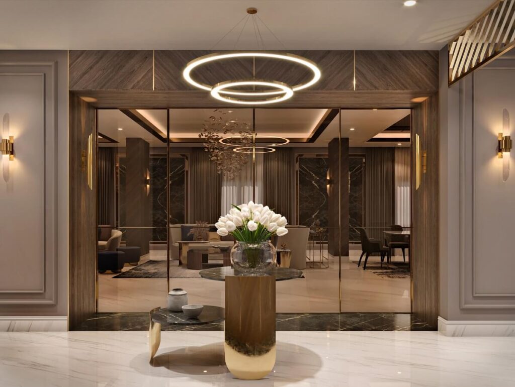 Luxury modern foyer design with chevron wood paneling, marble floors, and a gold circular halo chandelier.